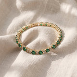 Elegante pulseira Tennis Trio dourada com esmeralda