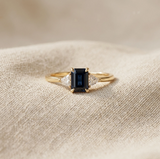 Anel elegante em dourado com espinela preta em corte baguete