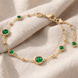 Pulseira elegante em dourado com uma bela esmeralda