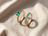 Conjunto elegante de dois anéis dourados com esmeralda