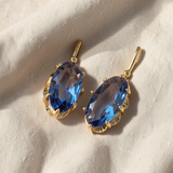 Brincos elegantes de dourado com safira azul em forma de flor