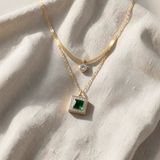 Colar de dourado elegante de duas camadas com esmeralda quadrada e detalhe de halo brilhante