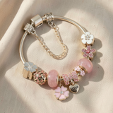 Elegante pulseira em dourado rosa com encantadores pendentes de flores e corações