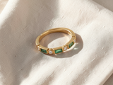 Anel elegante de dourado adornado com zircónias verdes