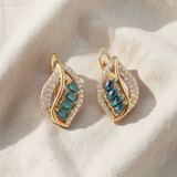 Brincos dourados elegantes, adornados com uma safira cintilante