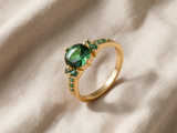 Anel elegante em dourado com esmeralda cintilante