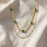 Colar Herringbone dourado duplo de luxo com detalhe de esmeralda em corte baguete