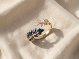 Anel elegante dourado com safira brilhante